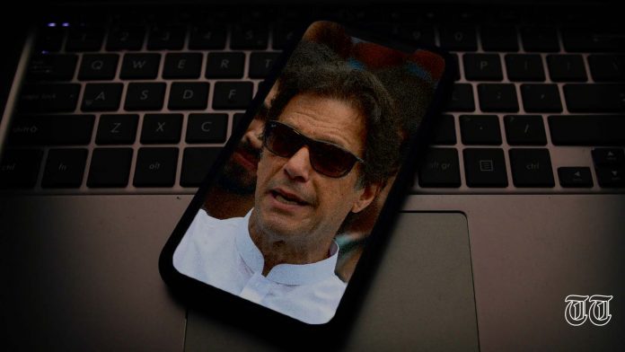 An illustration of a laptop supports a phone displaying a file photo of Prime Minister Imran Khan.