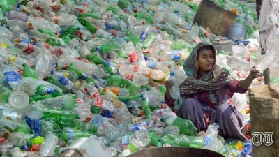 A file photo is shown of a woman sorting out plastic bottles at a warehouse in Lahore.