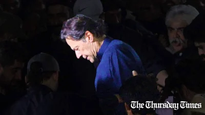 PTI chair Imran Khan looks down as he is escorted by members of the police. — FILE/THE THURSDAY TIMES