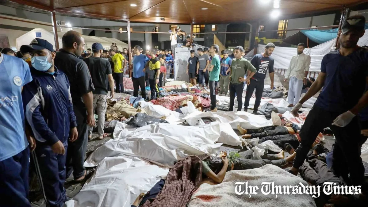 People gather around bodies of Palestinians killed in Israeli airstrikes on the Ahli Arab hospital in central Gaza after they were transported to Al-Shifa hopsital, on October 17, 2023. — DAWOOD NEMER/AFP