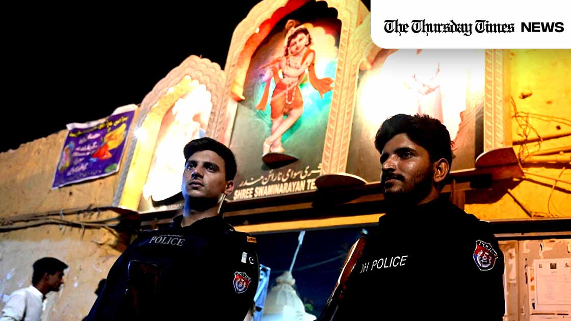 Police officers stand guard outside the Swami Narain Temple during Holi celebrations in Karachi on March 24, 2024. — AFP