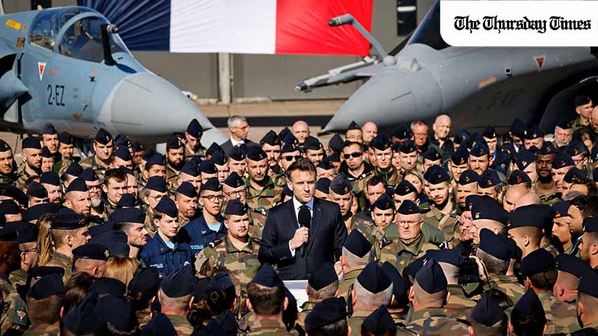 France's President Emmanuel Macron (C) delivers a speech in front of a Dassault Mirage 2000 (L) and a Dassault Rafale (R) fighter aircrafts during his visit of the French Air and Space Force (Armee de l'air et de l'espace) Luxeuil-Saint-Sauveur Airbase in Saint-Sauveur, north-eastern France on March 18, 2025. (Photo by Ludovic MARIN / POOL / AFP)