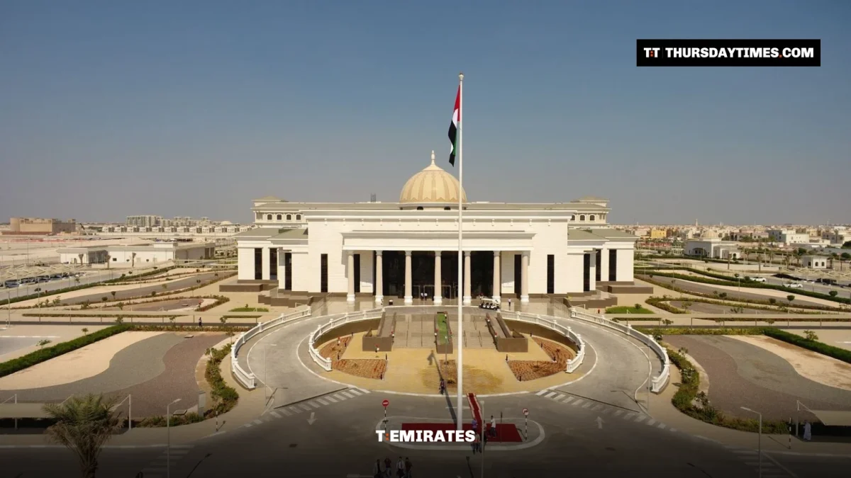 A white domed court building with a UAE flag on a tall pole in front, under a clear sky