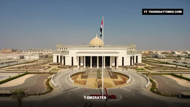 A white domed court building with a UAE flag on a tall pole in front, under a clear sky