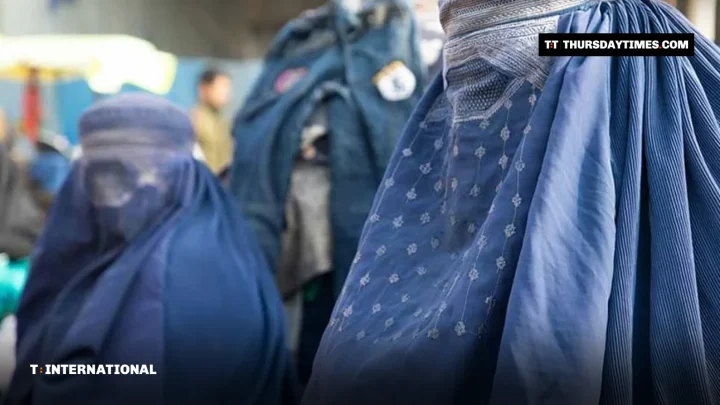 Two Afghan women in blue burqas at a market in Kabul
