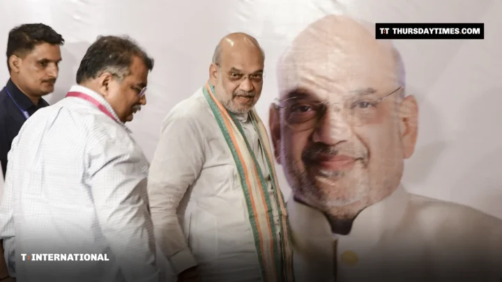 Amit Shah walks past a large portrait of himself at a party event