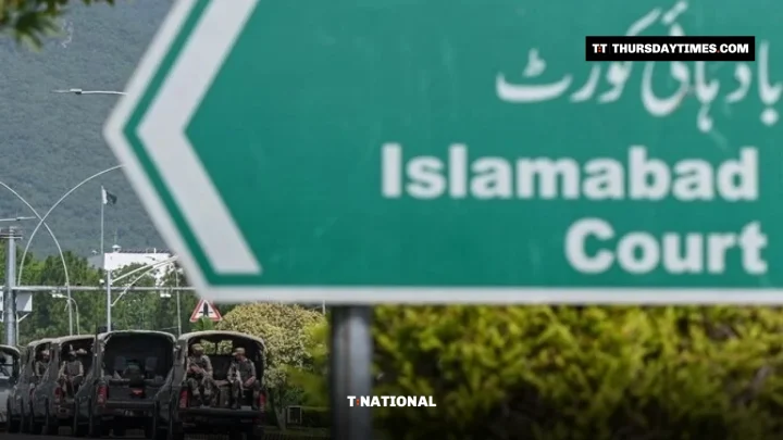 An army convoy drives past a road sign for the Islamabad High Court