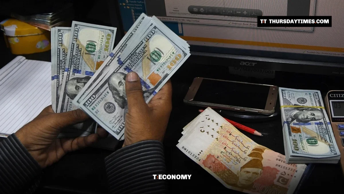 A dealer counts US dollars beside Pakistani rupee notes in Karachi
