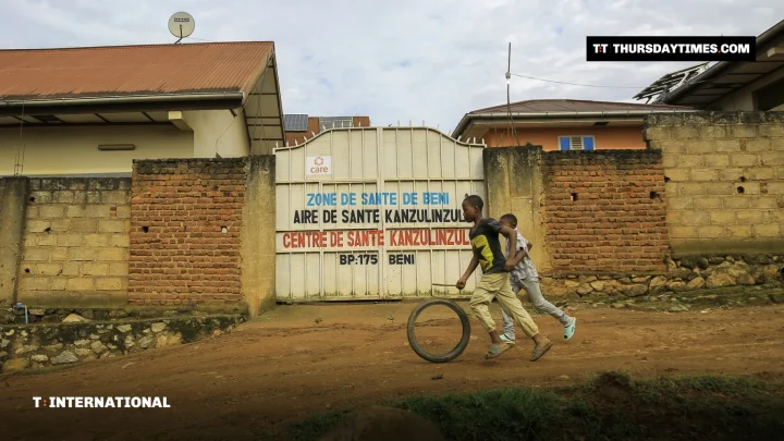 Children run past the gate of a health centre in Beni, eastern Congo