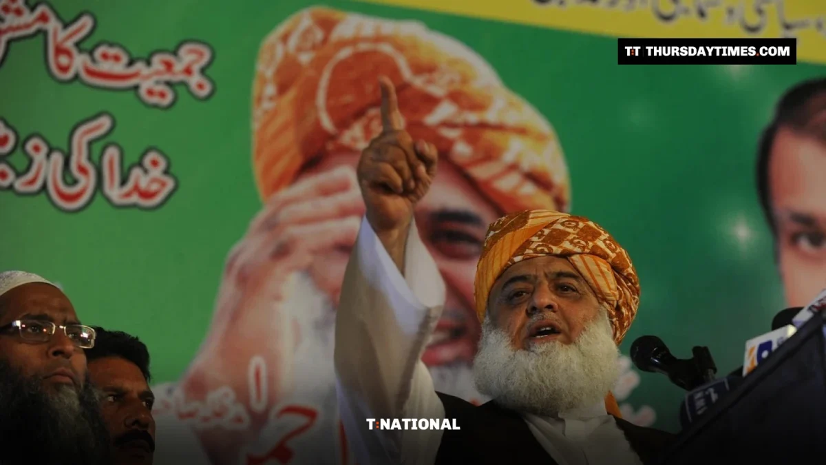 Maulana Fazlur Rehman in an orange turban raises a finger as he speaks at a rally