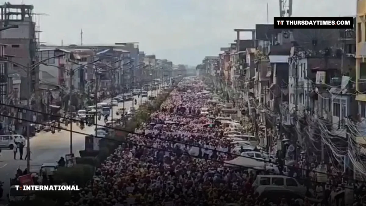 A huge crowd of protesters fills a long street in Imphal