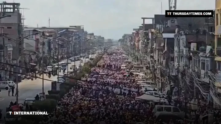 A huge crowd of protesters fills a long street in Imphal
