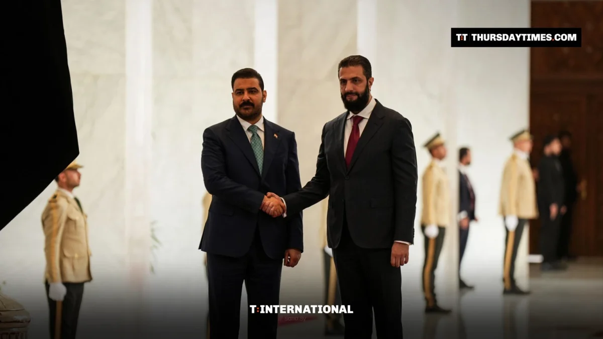 Ahmed al-Sharaa and Ali al-Zaidi shake hands in a marble hall with honour guards behind them