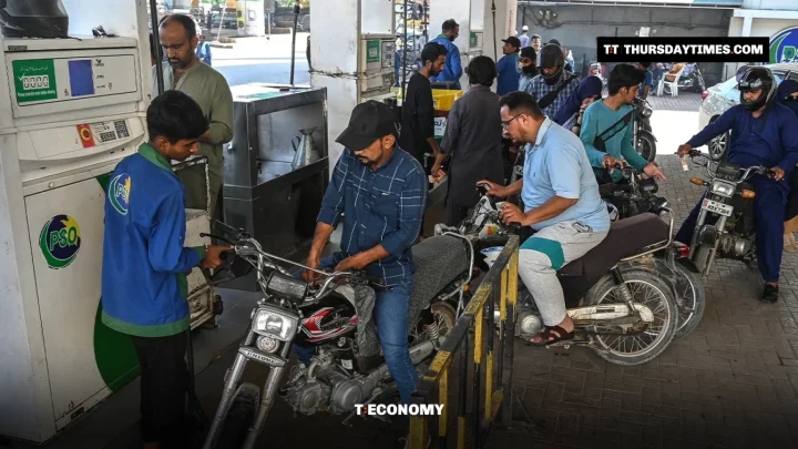 A pump attendant fills a motorcycle as riders queue at a PSO petrol station in Karachi