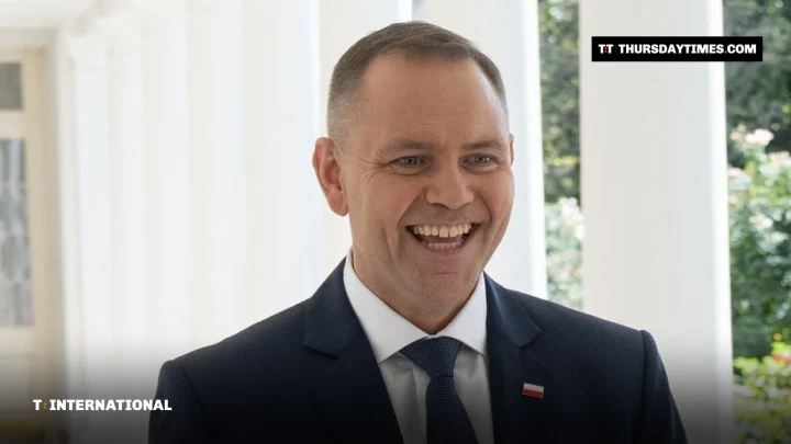 Polish President Karol Nawrocki walking along a colonnade