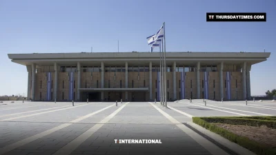 The Knesset building in Jerusalem with an Israeli flag in front
