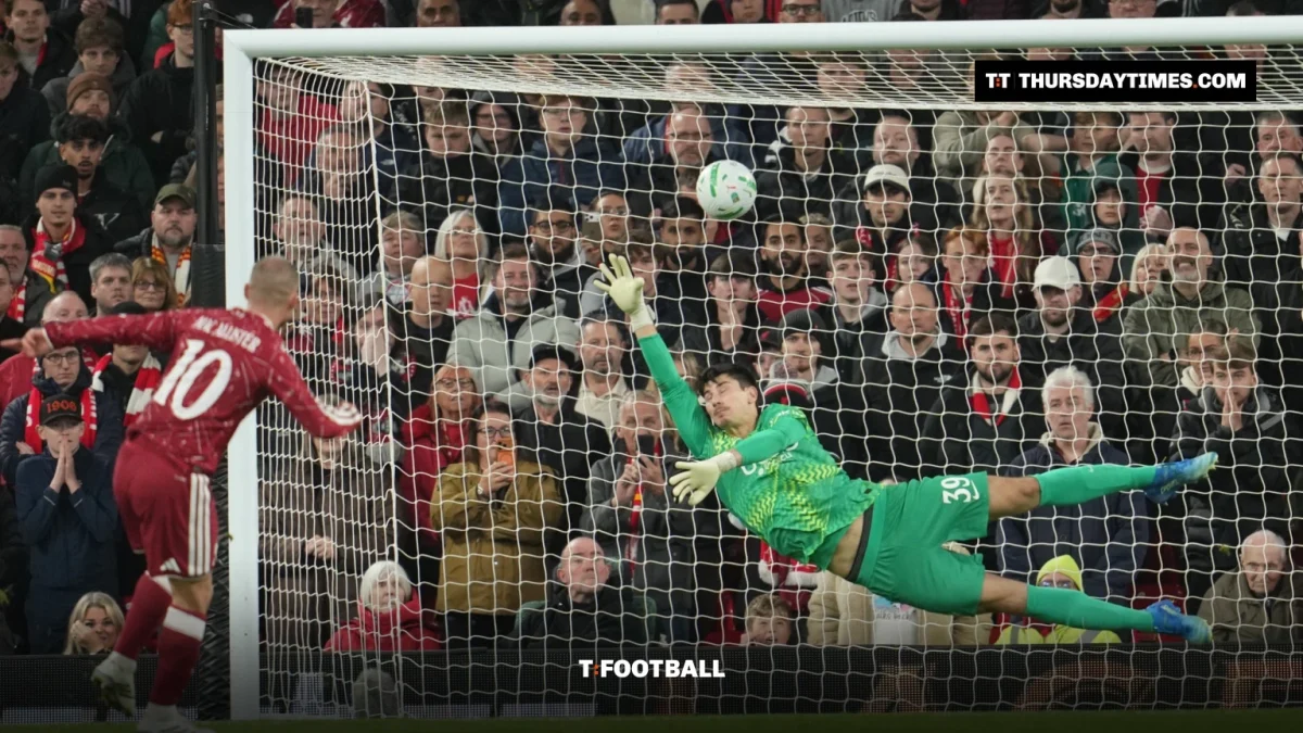 A Liverpool player scores a penalty as the Chelsea goalkeeper dives the wrong way in front of the Kop