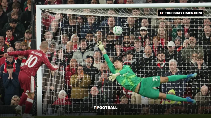 A Liverpool player scores a penalty as the Chelsea goalkeeper dives the wrong way in front of the Kop