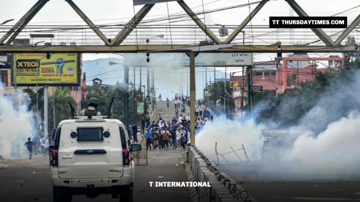 Tear gas smoke on a road in Imphal as a security vehicle approaches protesters