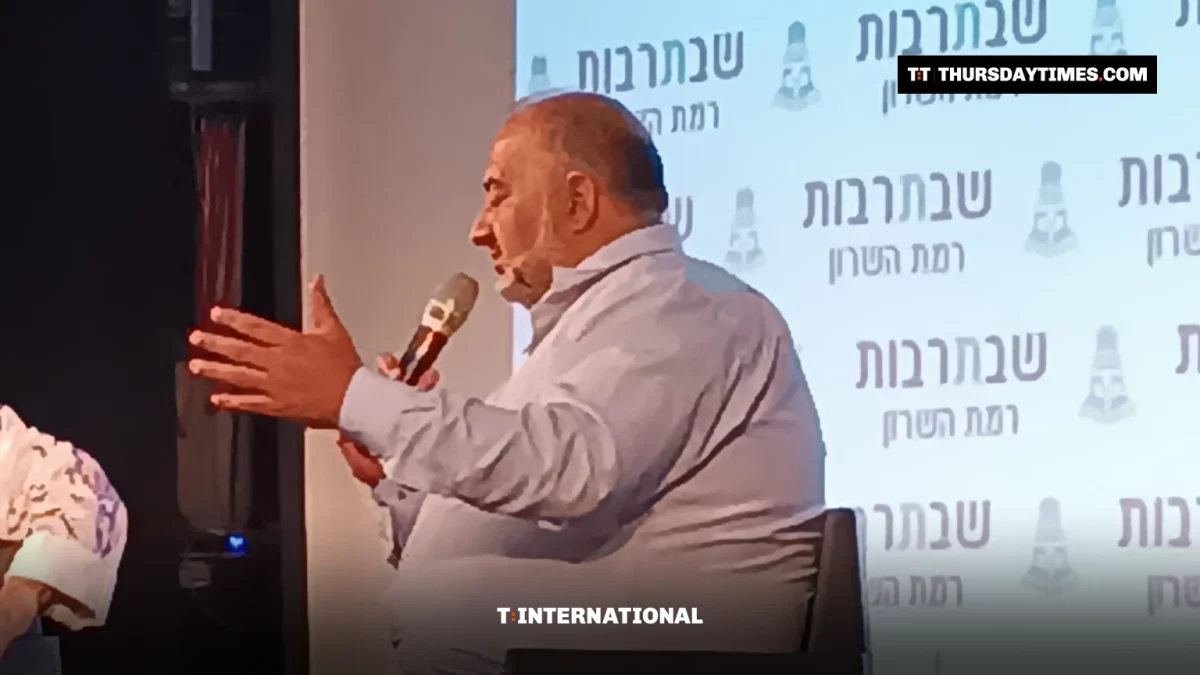 Mansour Abbas gestures while speaking into a microphone on stage