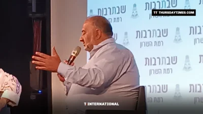 Mansour Abbas gestures while speaking into a microphone on stage