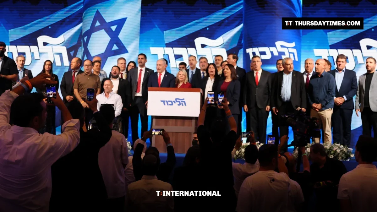Netanyahu speaks at a Likud podium flanked by party members as supporters film on their phones