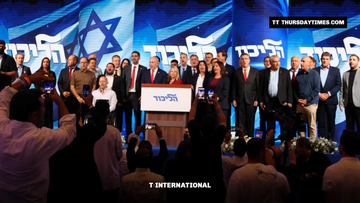 Netanyahu speaks at a Likud podium flanked by party members as supporters film on their phones