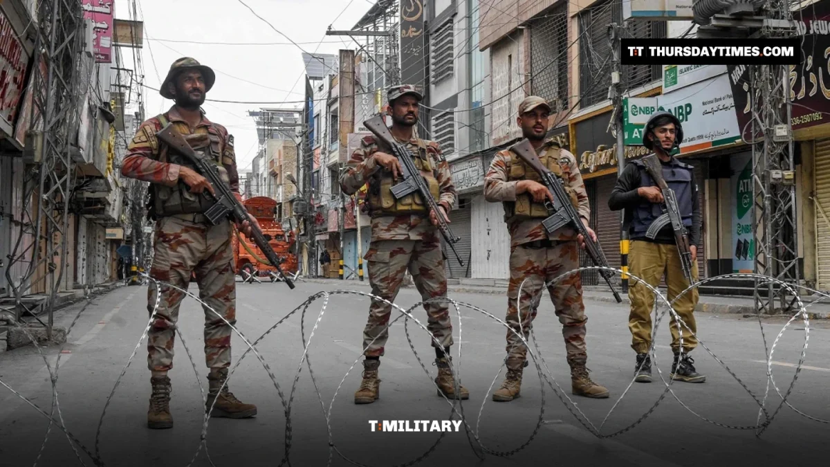 Armed Pakistani soldiers stand behind razor wire on a Quetta street