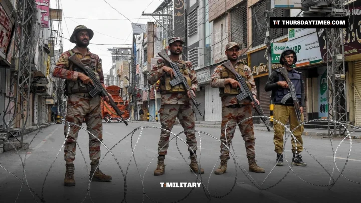 Armed Pakistani soldiers stand behind razor wire on a Quetta street