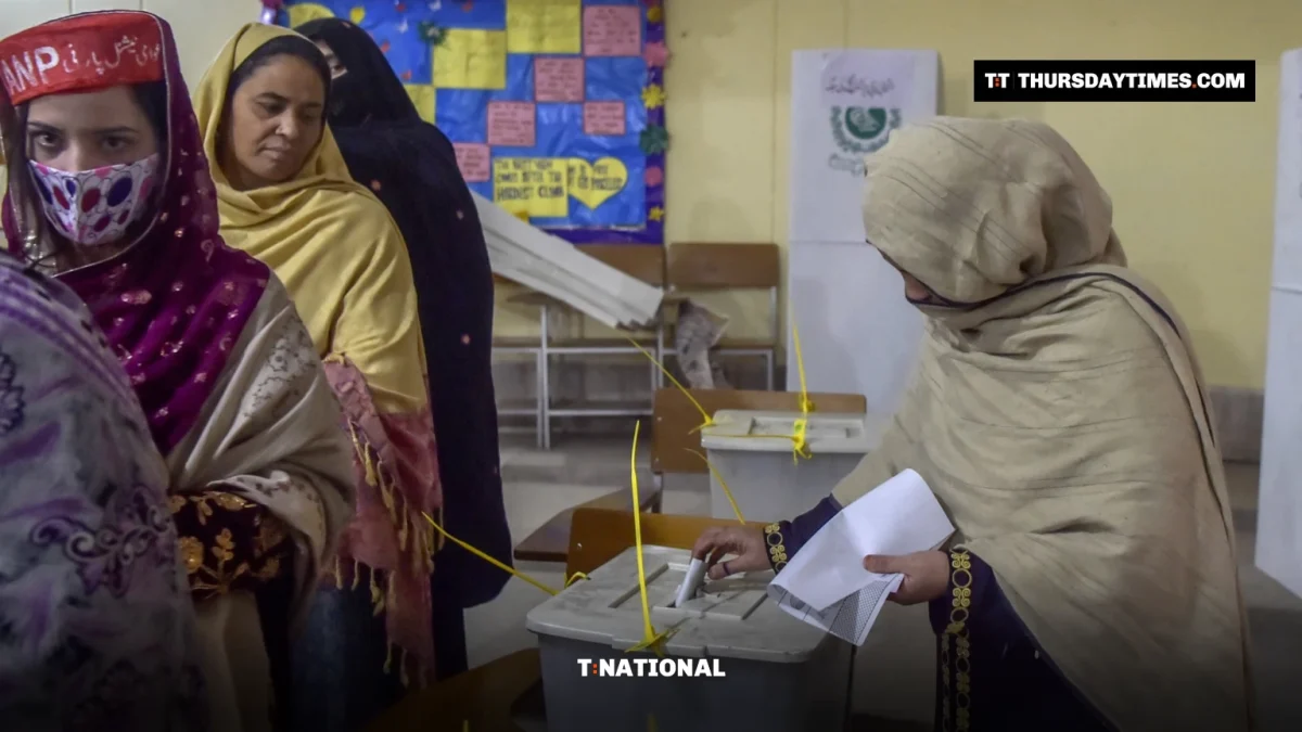 A woman casts her ballot as other women queue at a polling station in Peshawar