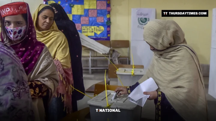 A woman casts her ballot as other women queue at a polling station in Peshawar