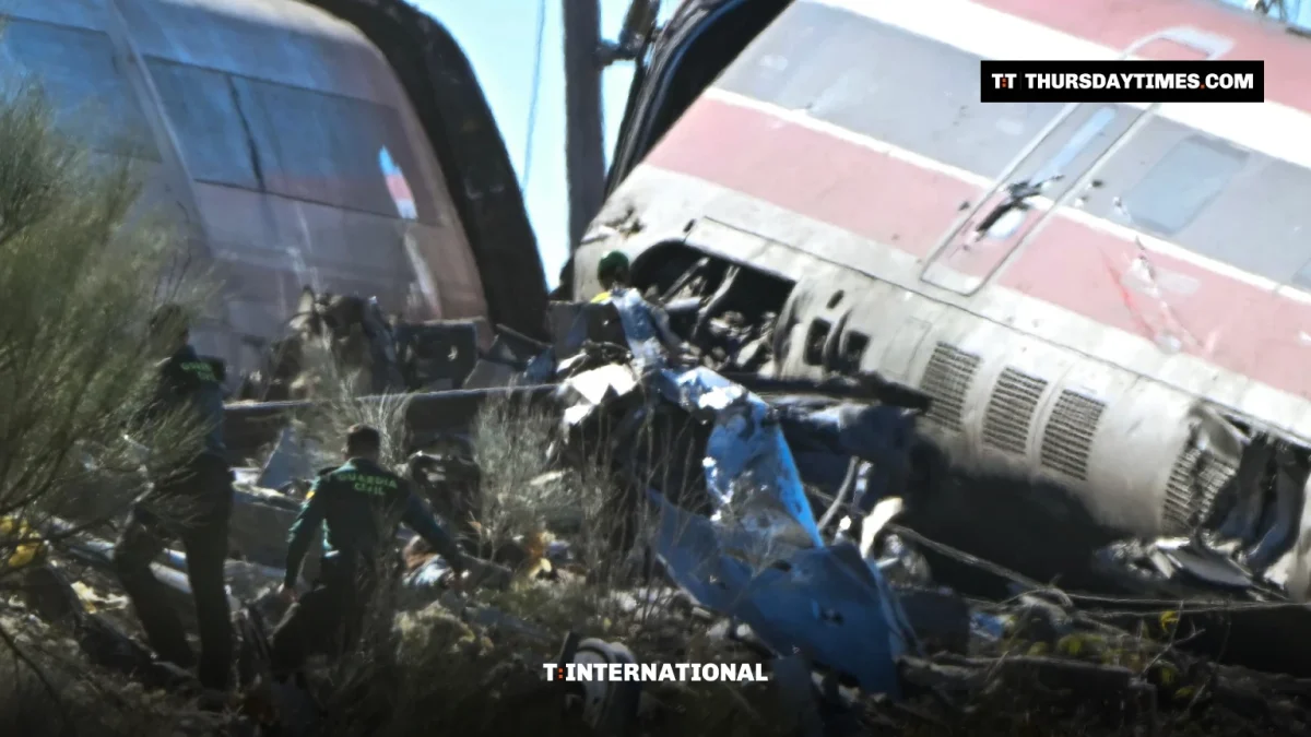 Civil Guard officers walk past mangled high-speed train carriages near Urda