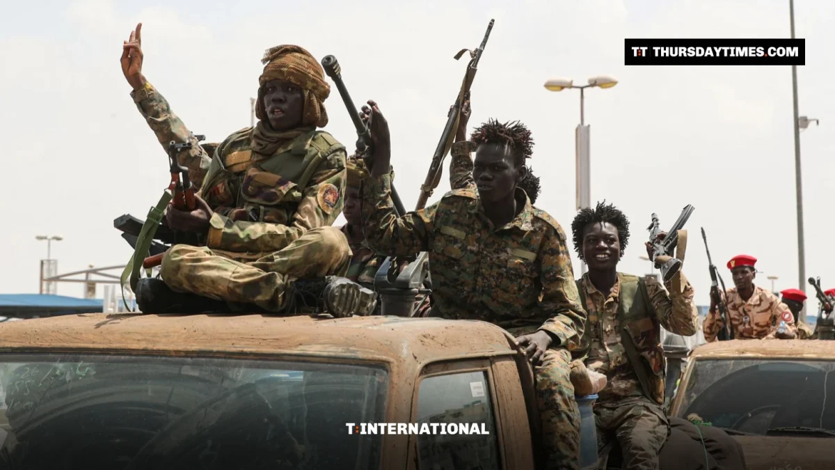 Armed fighters sit atop a pickup truck in Sudan, one raising his hand