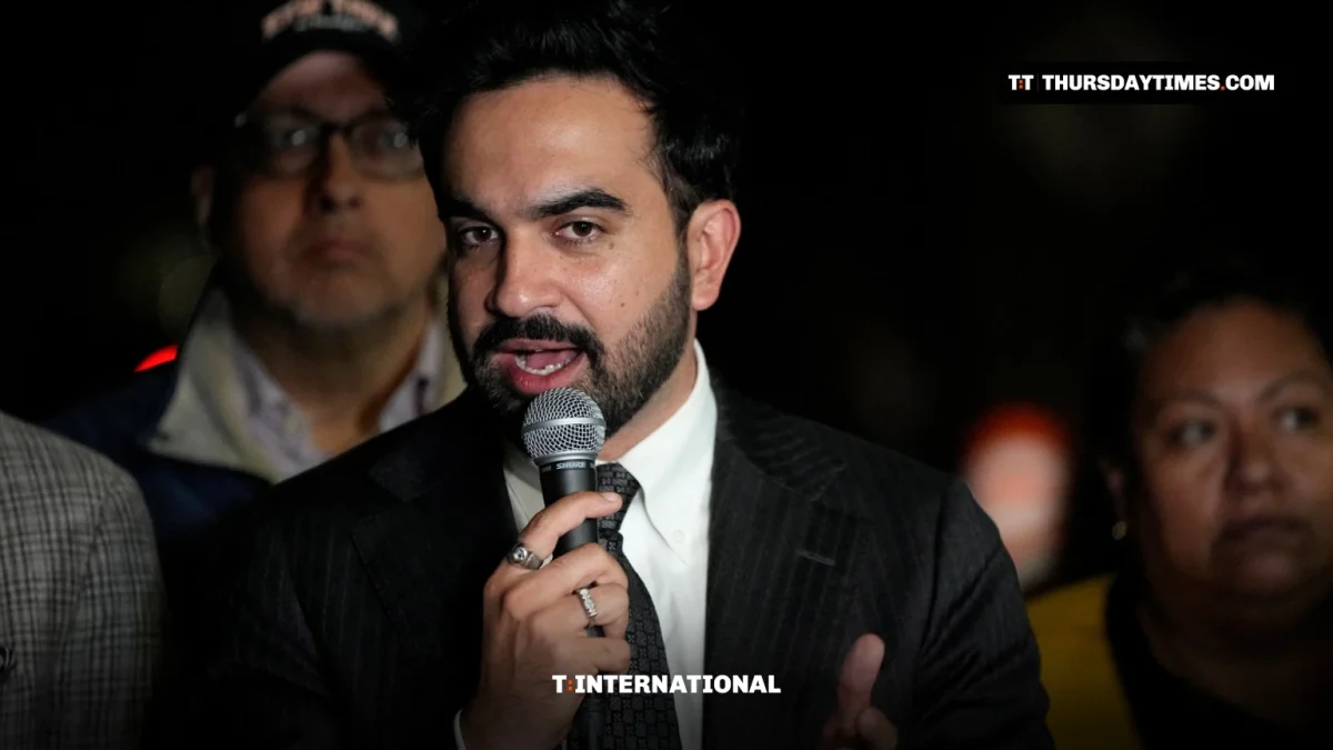 Zohran Mamdani speaks into a microphone at a night-time news conference